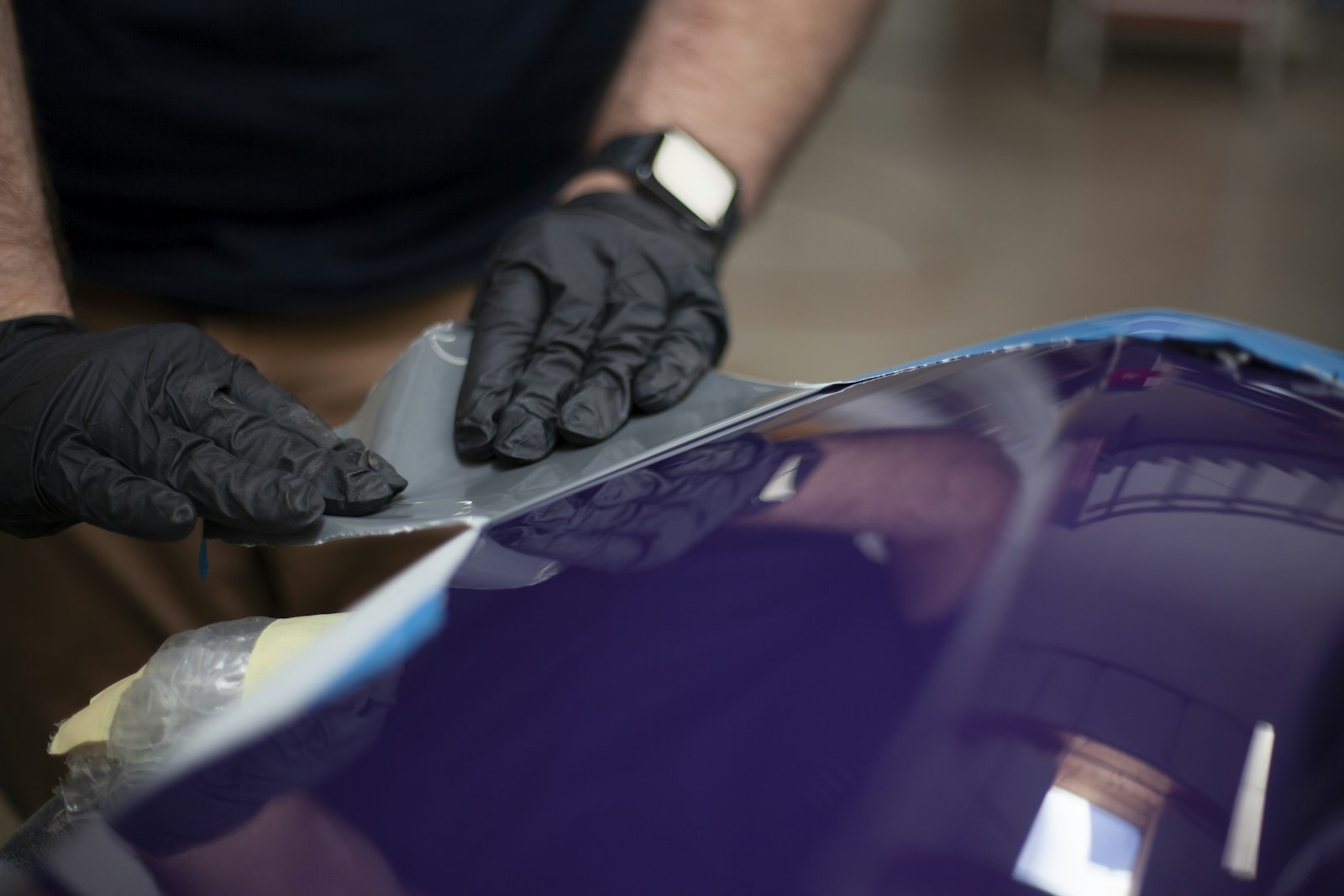 Gloved hands applying protective film