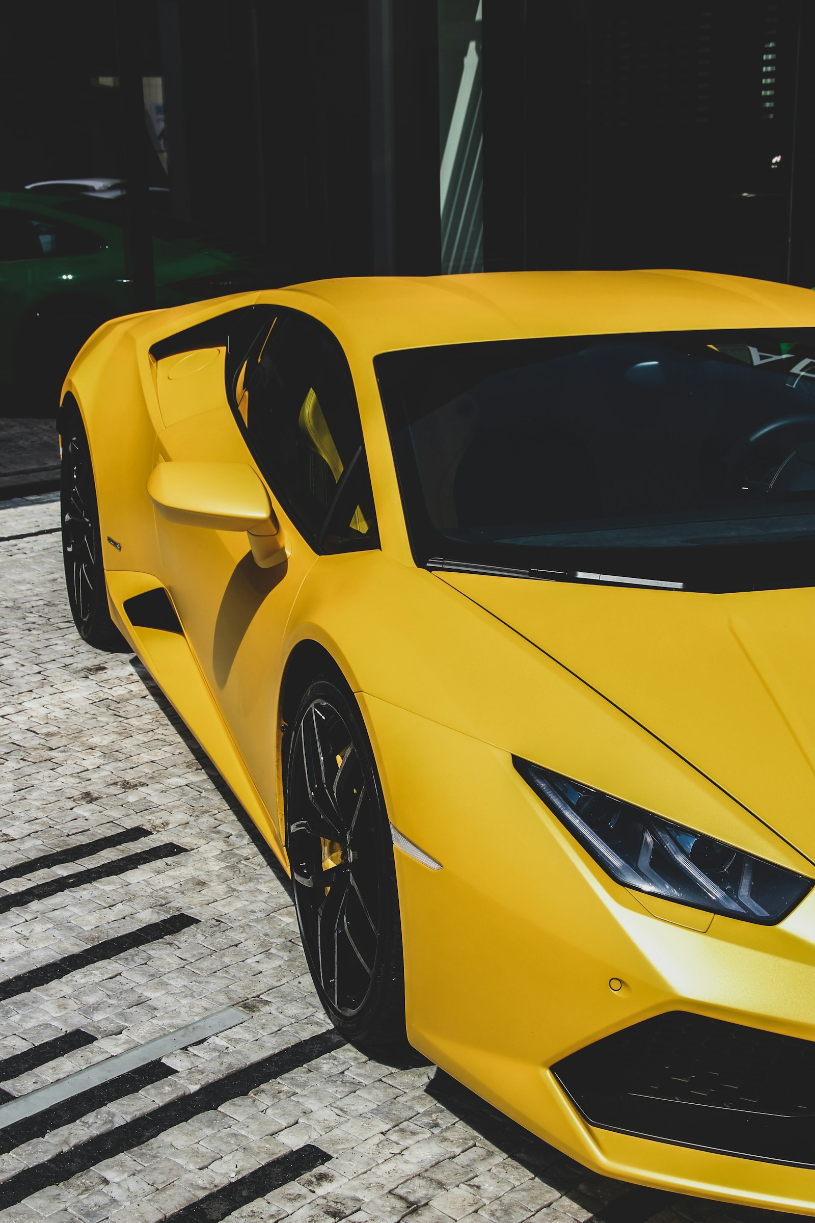A yellow supercar revealed under directional light